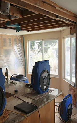 Triad air movers drying a water-damaged kitchen after restoration.