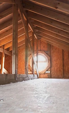 Unfinished attic space with wood framing and a round window, relevant to attic mold removal.