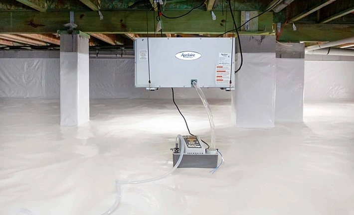 Crawlspace dehumidifier setup featuring an Aprilaire unit, condensation pump, and encapsulated space.