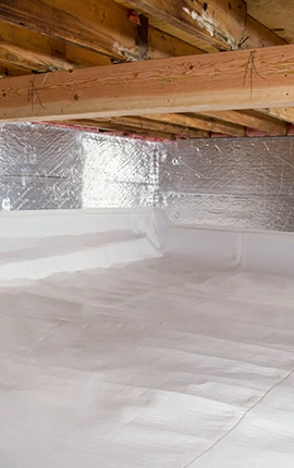 Clean crawl space with white vapor barrier and insulated floor joists, showcasing local knowledge in home maintenance.