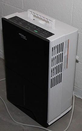 Dehumidifier against a wall, used for moisture removal in a home.