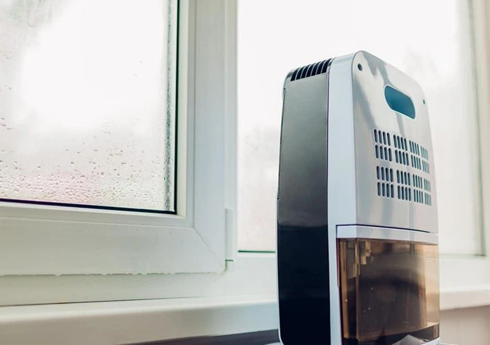 Dehumidifier next to a window with condensation, relevant for dehumidifier installation.