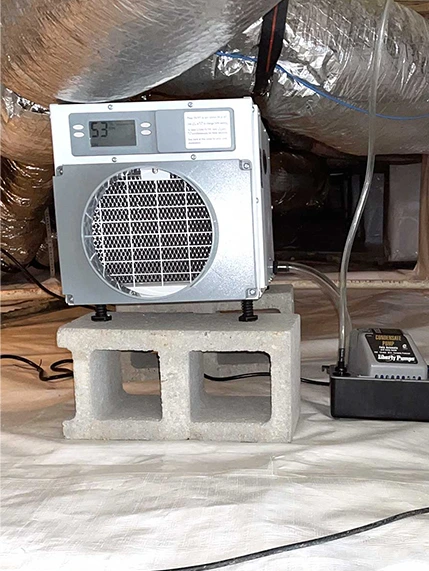 Crawl space dehumidifier on cinder block with condensate pump.