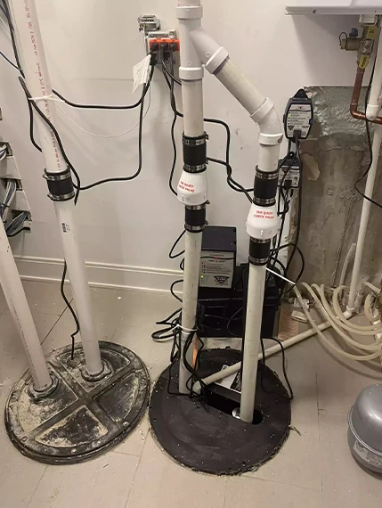 Dual sump pump system with backup battery in basement, for sump basin service.